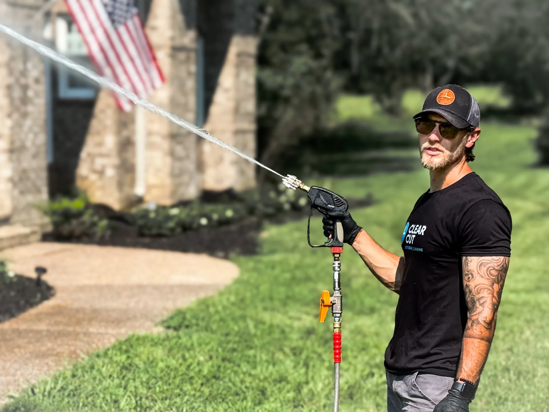 Clear Cut Exterior Cleaning owner soft washing a stone home in Middle Tennessee